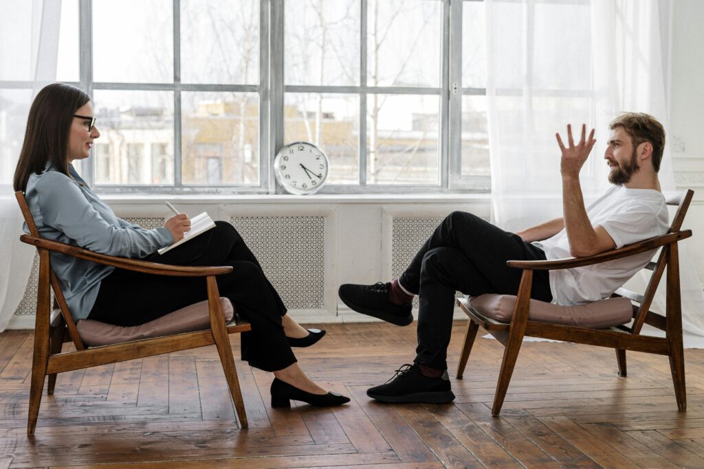 pexels-photo-4101143-4101143 A therapist engaging in a counseling session with a male patient to support mental health.